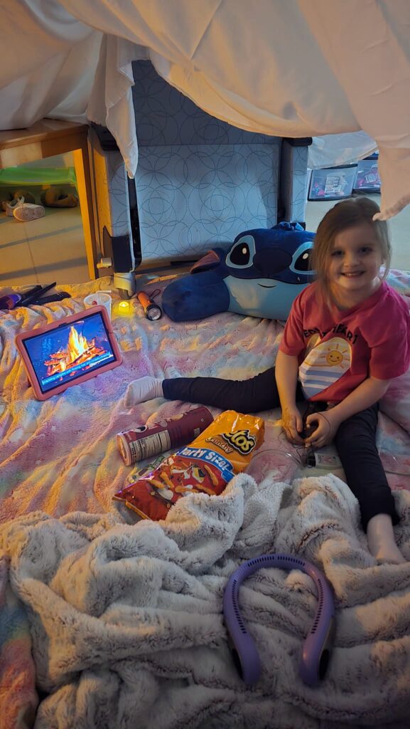 Evelyn inside a blanket fort