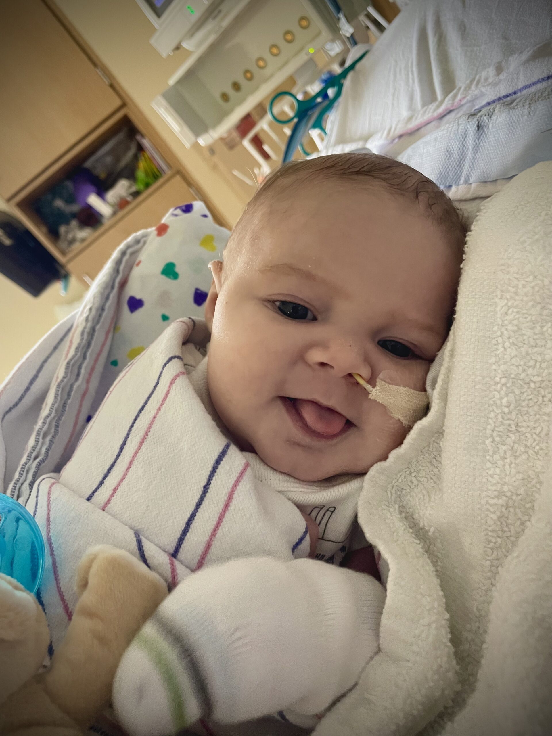 Oliver (Ollie) Fox Payton smiling in his hospital bed.